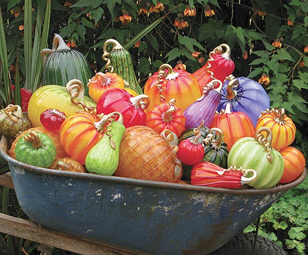 A wheelbarrow full of glass pumpkins on display during the Cohn-Stone Studios Spring Garden Exhibition.